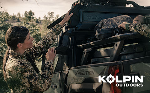 People securing Kolpin Outdoors cargo boxes on a Polaris XPEDITION vehicle.