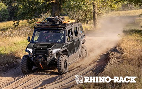 Polaris XPEDITION ADV 4-Seat vehicle with Rhino-Rack rooftop cargo system on a dirt road.