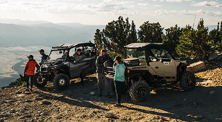 A group of Polaris General riders with two vehicles on the mountain