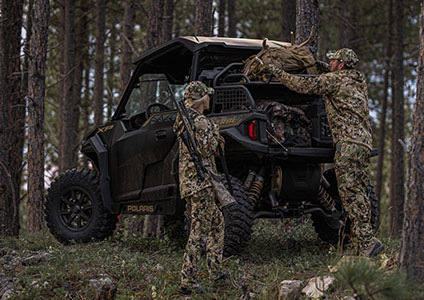 Un chasseur qui met de l’équipement dans les options de rangement rhino-rack dans le coffre de son GENERAL XP 1000