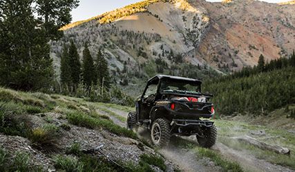 Polaris GENERAL XP 1000 with a full cargo box driving up a hill