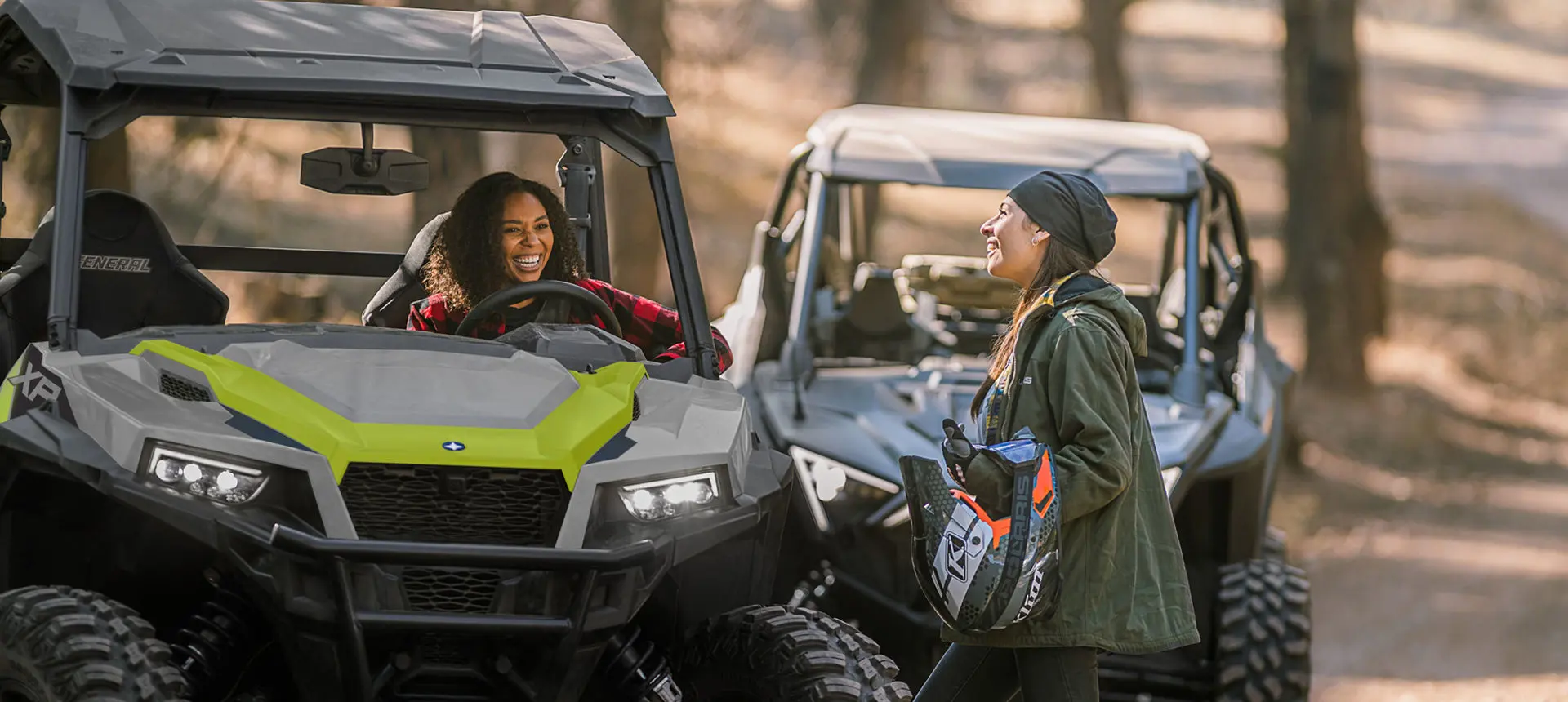 couple unloading their general xp 1000 side by side near a forest trail