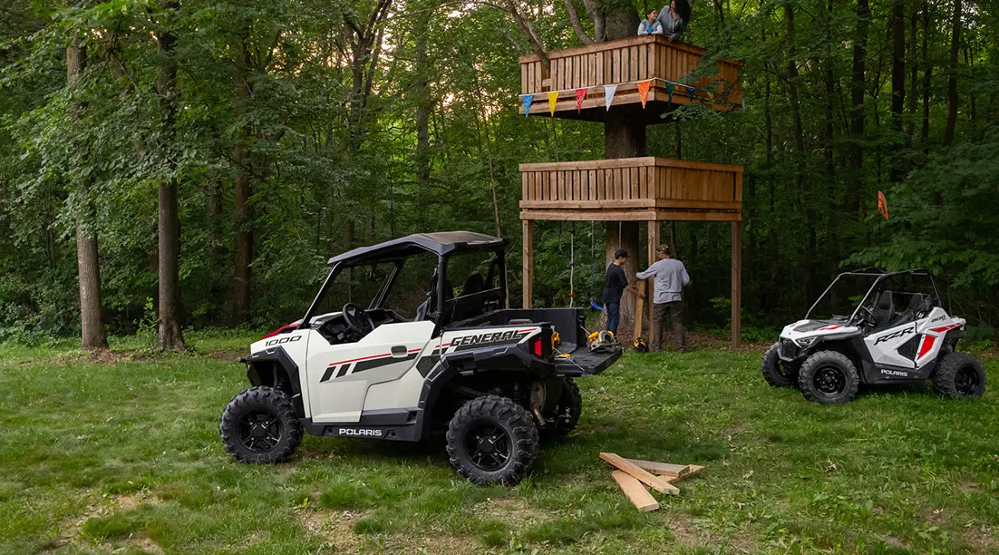 father and son building a tree house by hauling lumber with their general xp 1000 side by side