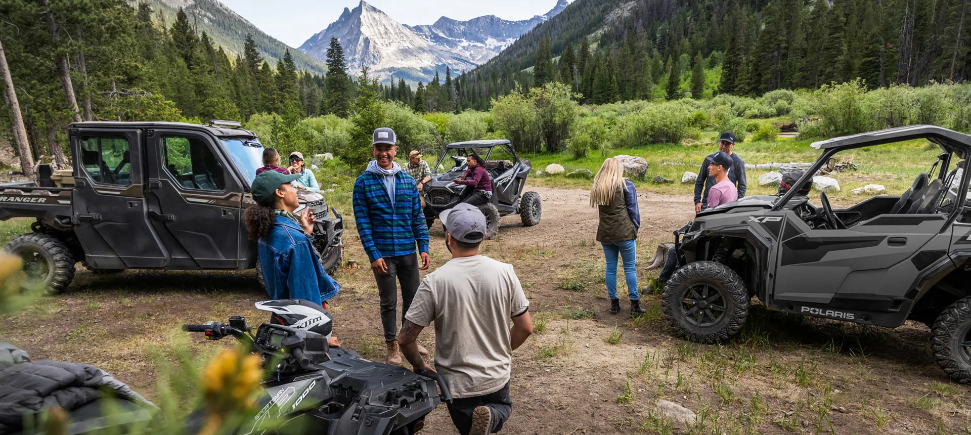 des amis se réunissant pour une promenade près de leurs véhicules hors route polaris