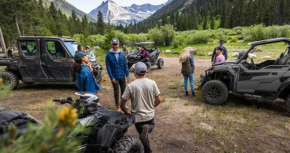 des amis se réunissant pour une promenade près de leurs véhicules hors route polaris