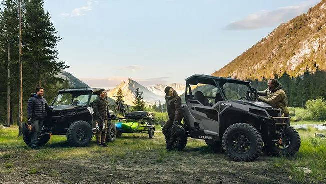 friends relaxing after a ride in their general xp 1000 side by sides