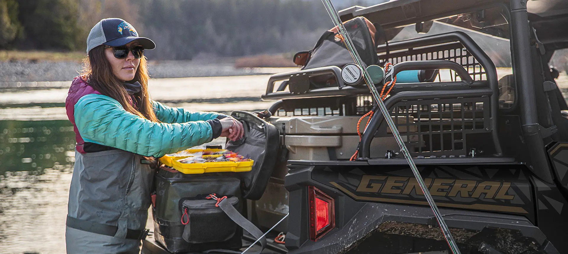 woman getting tackle from the cargo box of her general xp 1000 side by side