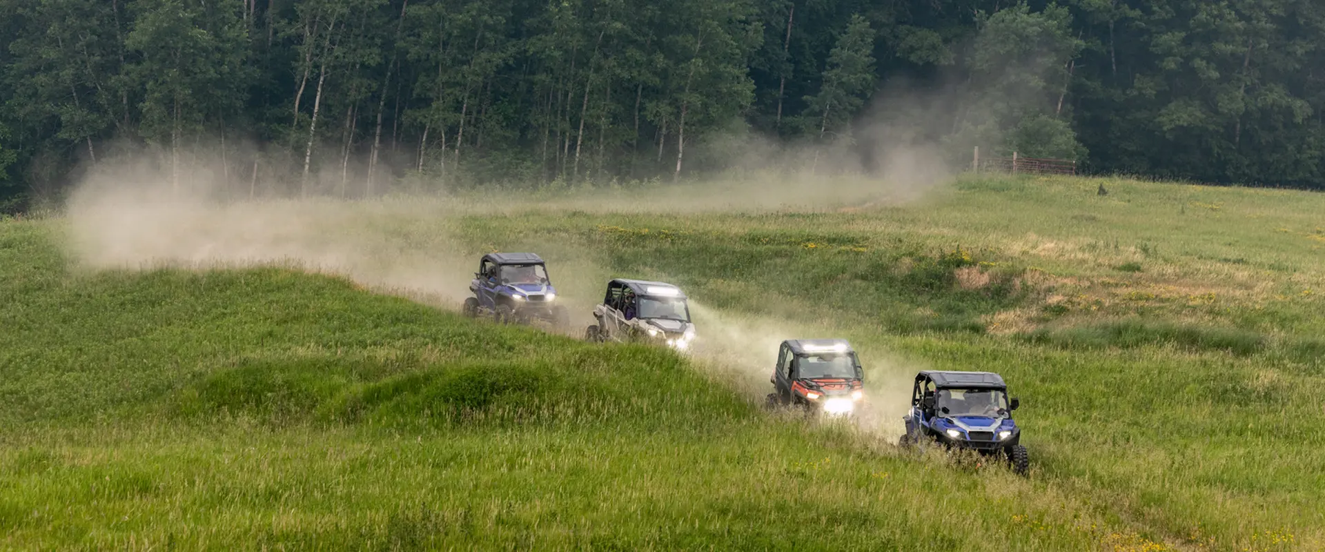 4 general xp 1000 side by sides driving through a field