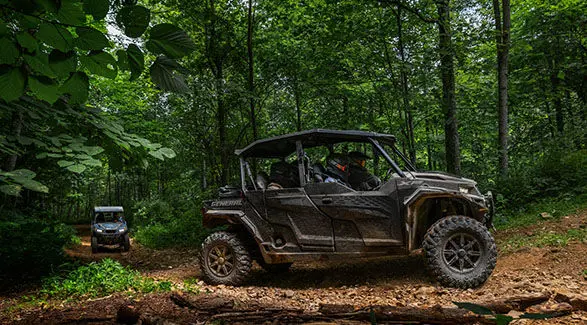 Side view of a 2025 Polaris GENERAL XP 4 1000 side-by-side trail riding while a 2025 Polaris GENERAL XP 1000 side-by-side follows behind.