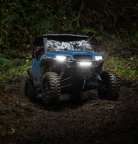 A 2026 Polaris GENERAL XP 1000 SxS UTV climbing uphill showcasing its trail-capable power for near limitless exploration.