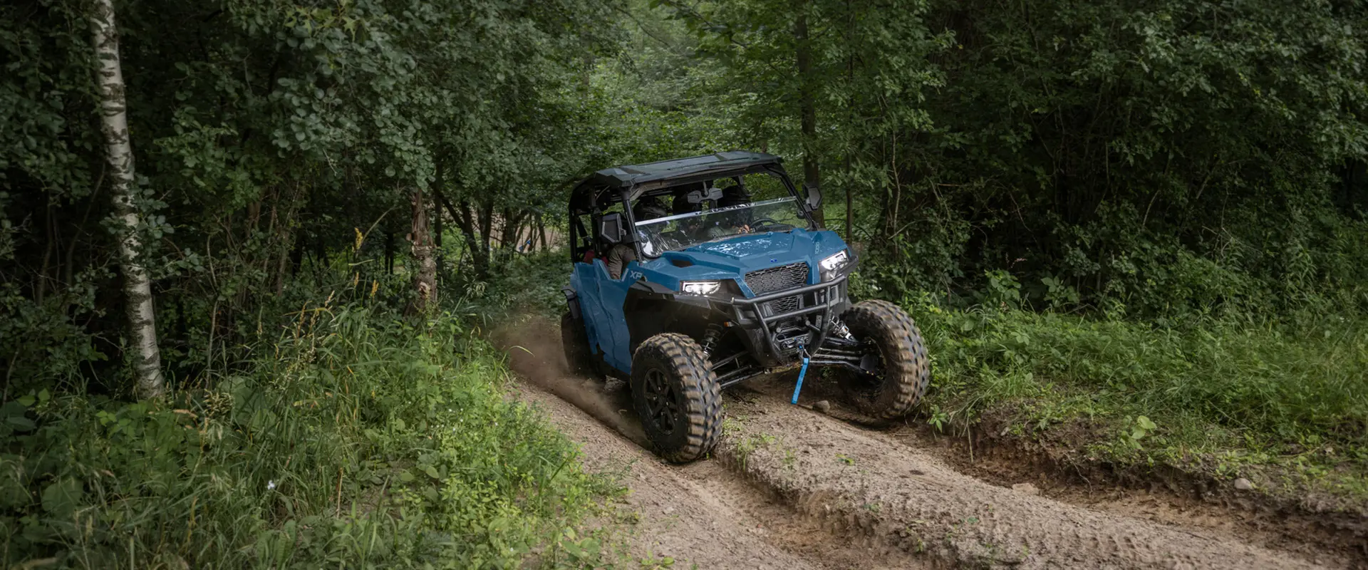 A 2026 Polaris GENERAL XP 4 1000 crossover side-by-side cruising on a trail.