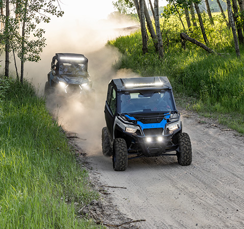 2 2027 Polaris GENERAL 1000 side-by-sides driving down a dusty trail.