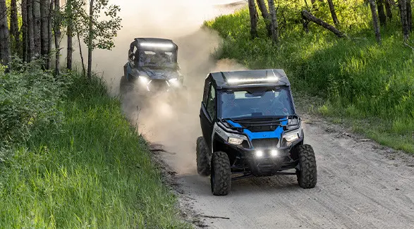 2 2027 Polaris GENERAL 1000 side-by-sides cruising down a dusty trail.