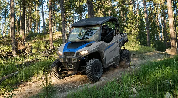 A 2027 Polaris GENERAL 1000 side-by-side descending a rocky hill.