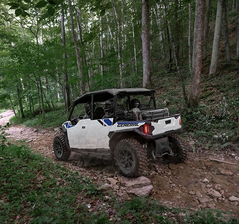 4 riders in a 2027 Polaris GENERAL XP 4 1000 SXS comfortably driving over a rocky trail.