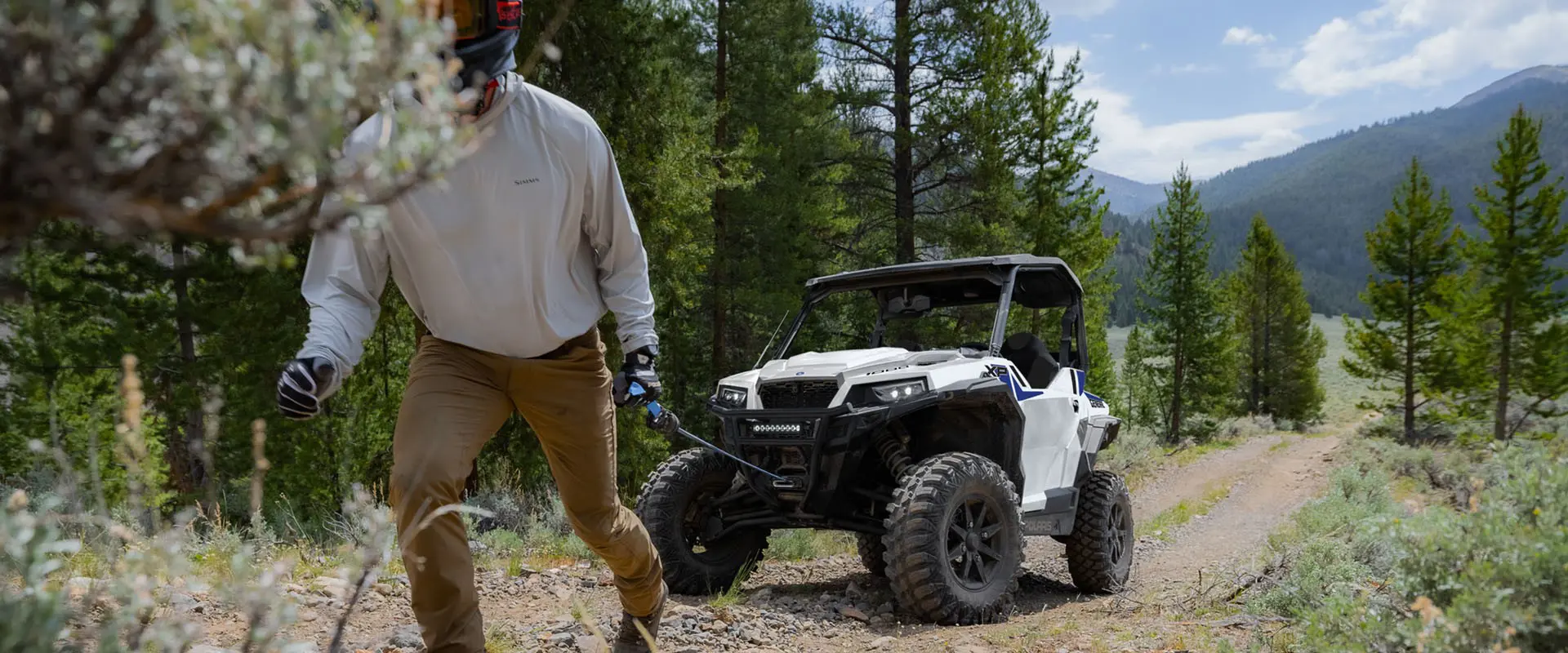 Person pulling the winch out of the front-end of a 2027 Polaris GENERAL XP 1000 side-by-side.