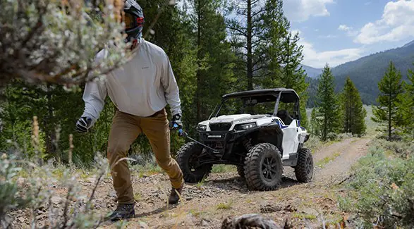 Person pulling the winch out of the front-end of a 2027 Polaris GENERAL XP 1000 side-by-side.