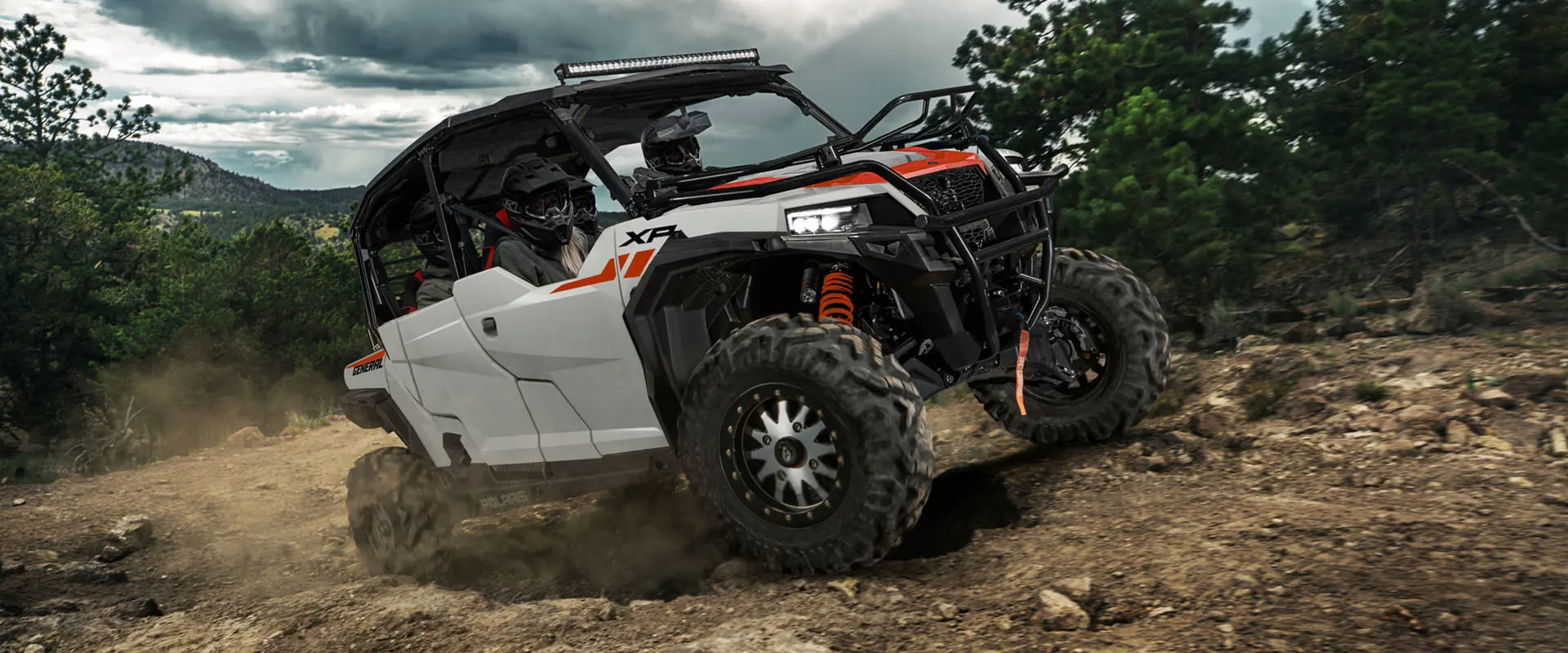 4 riders in a 2027 Polaris GENERAL XP 4 1000 side-by-side climbing over rocky terrain with ease.