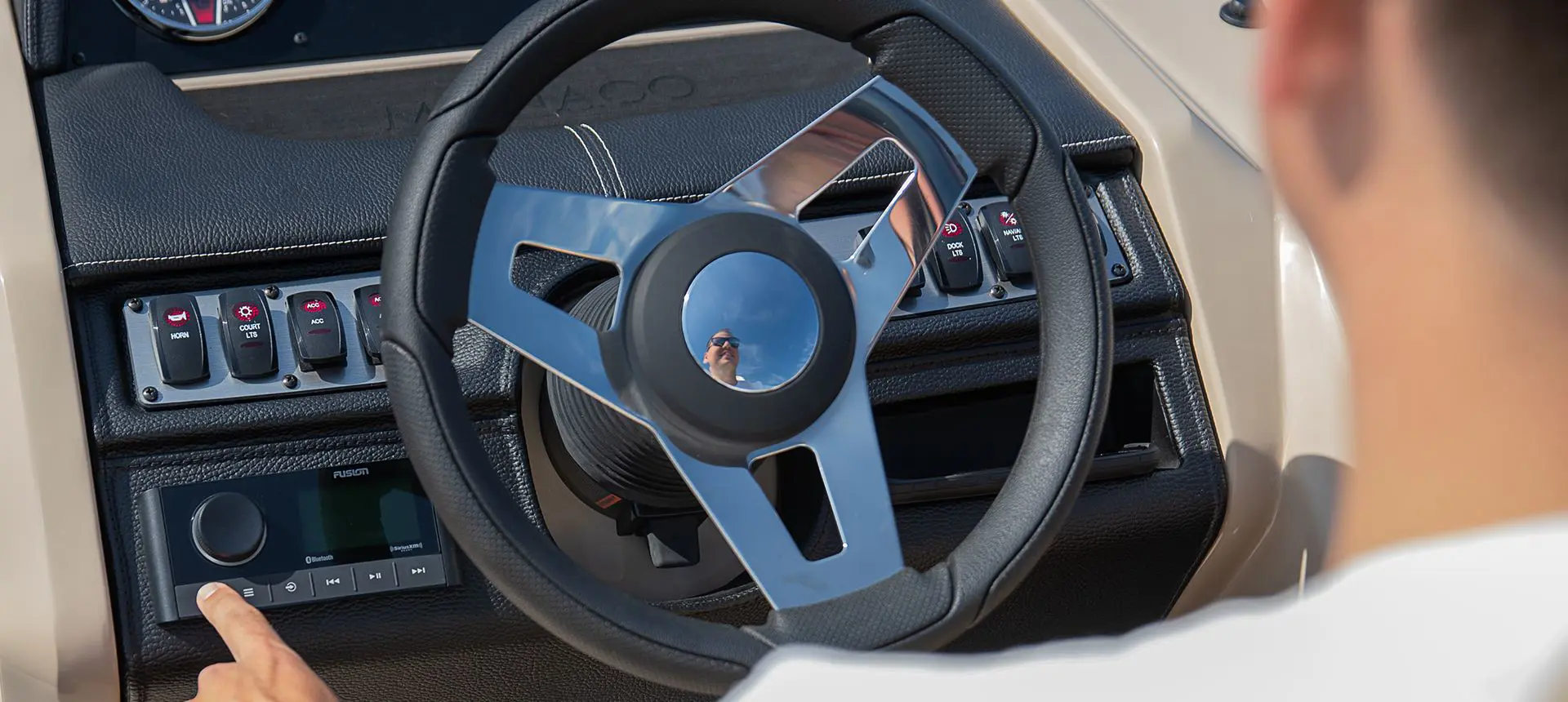 Steering wheel and gauges on the helm of a Godfrey Monaco Lounge pontoon boat.