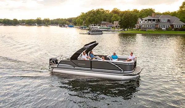 side profile of a godfrey monaco lounge pontoon cruising on a lake