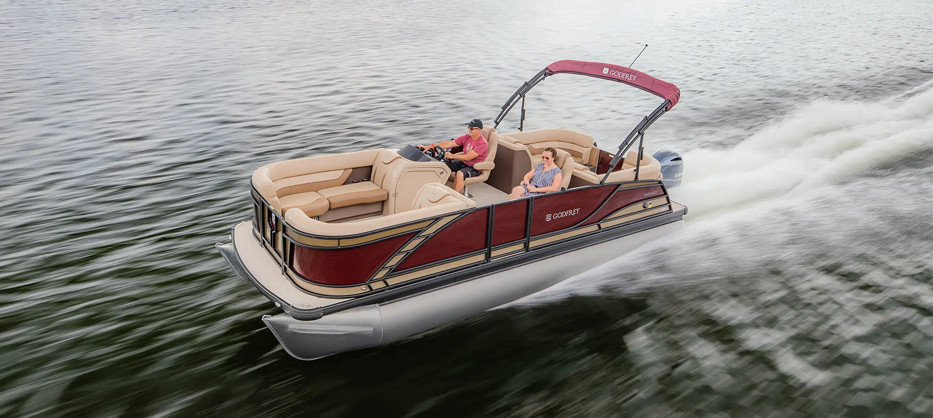 godfrey monaco split bench pontoon speeding across a lake
