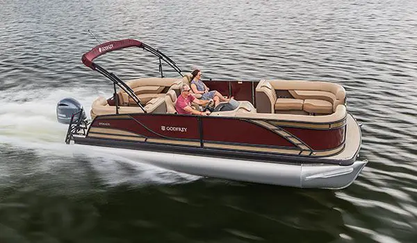 couple relaxing while speeding across a lake on a godfrey monaco split bench pontoon