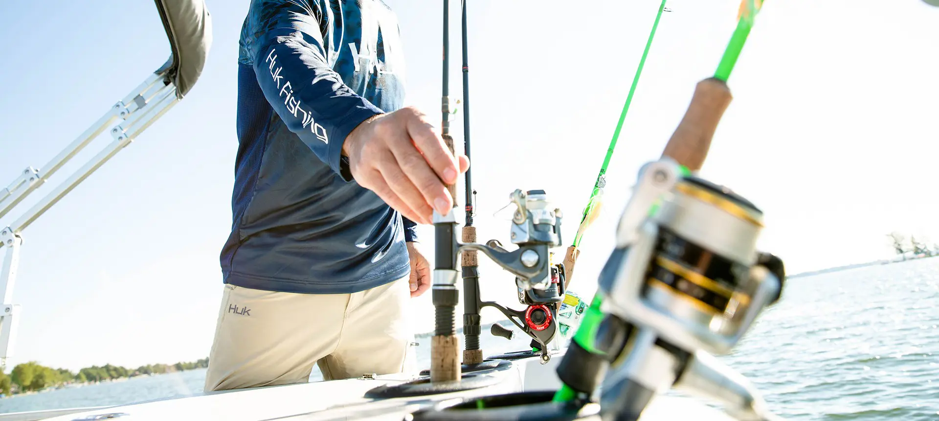 homme saisissant le poteau des porte-cannes intégrés sur un ponton godfrey Sweetwater Fishing