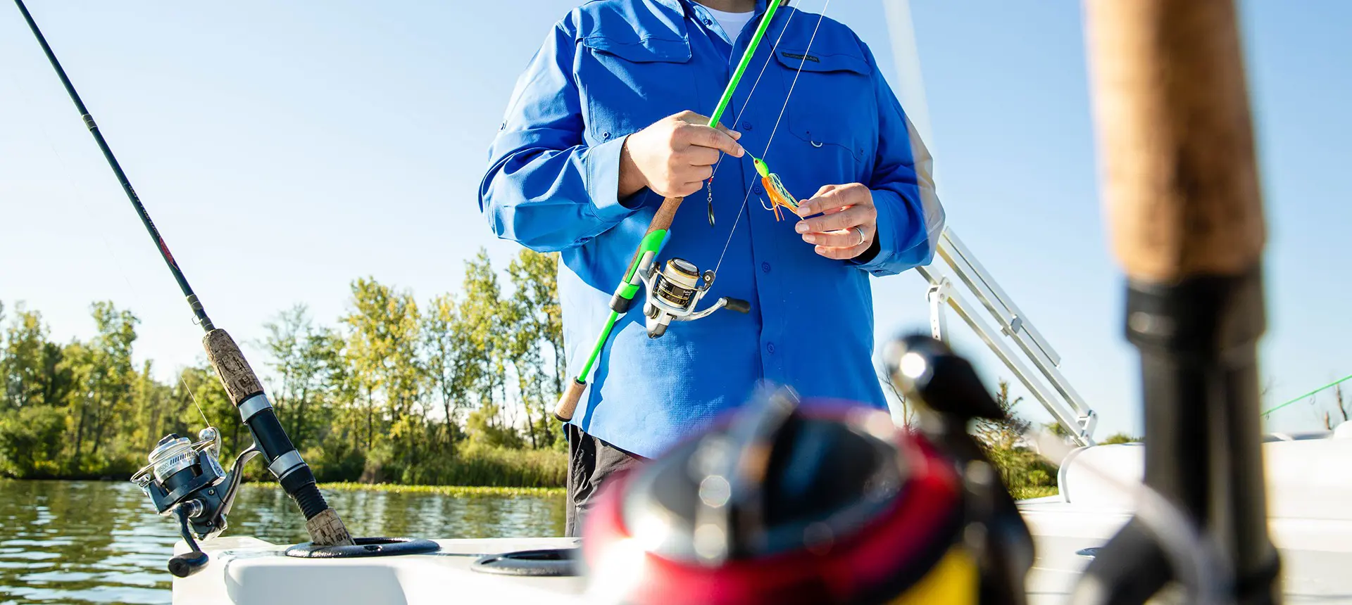homme mettant un appât tournant sur sa canne à pêche sur un ponton godfrey sweetwater fishing