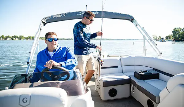 2 hommes sur un ponton godfrey sweetwater fishing naviguant jusqu’à leur lieu de pêche