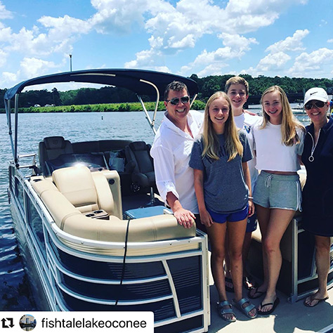 Family posing in front of Godrey boat