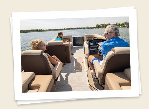 couple relaxing in the captain's chairs on a godfrey aquapatio split bench pontoon