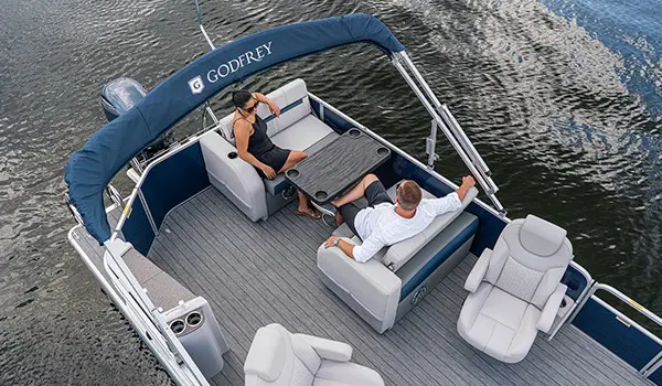 family relaxing at the table on a godfrey sweetwater entertainment pontoon