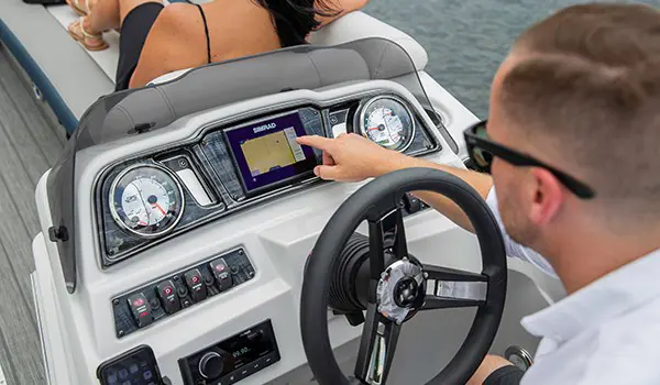 man using sitting at the redesigned helm on a godfrey sweetwater entertainment pontoon