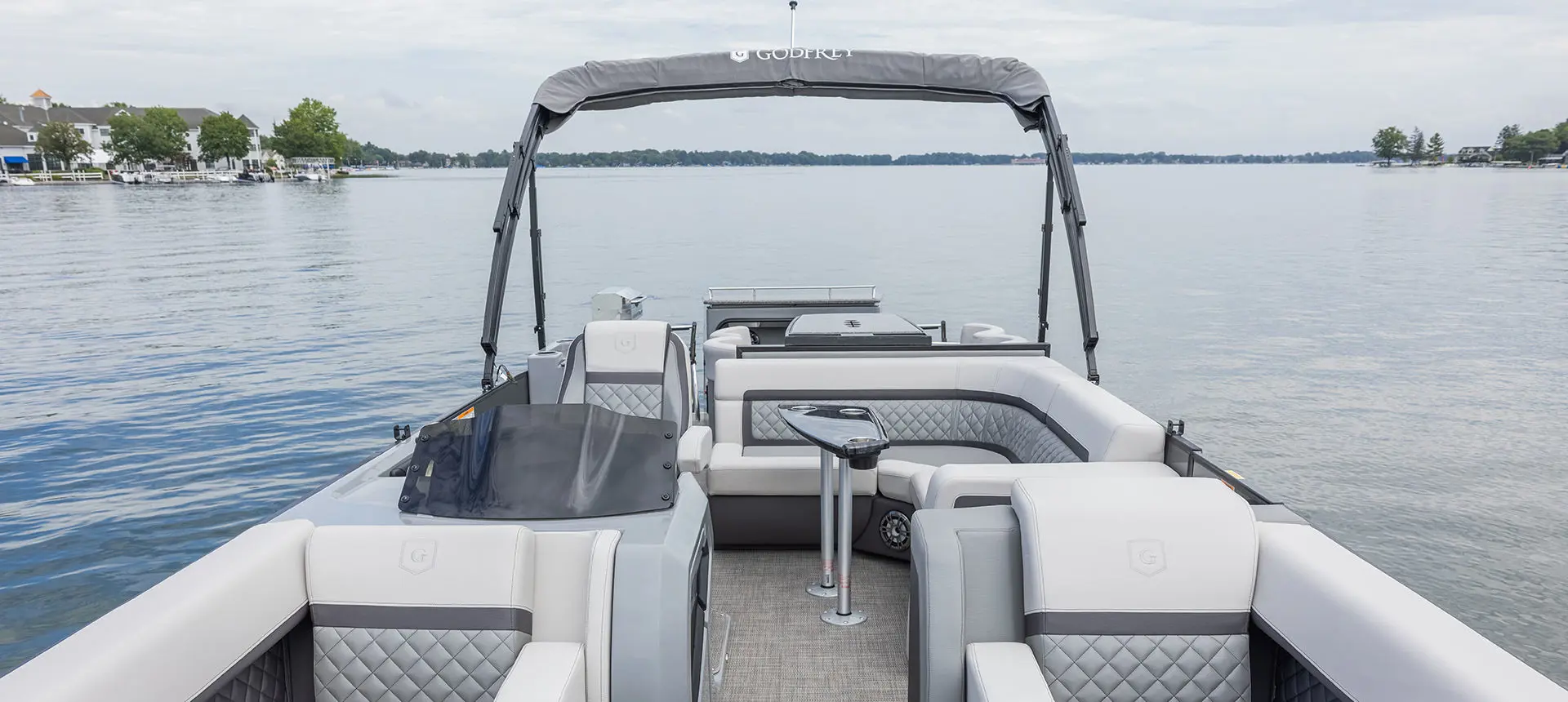split bench seats, midship couch and table, and stern table on a godfrey aquapatio entertainment pontoon