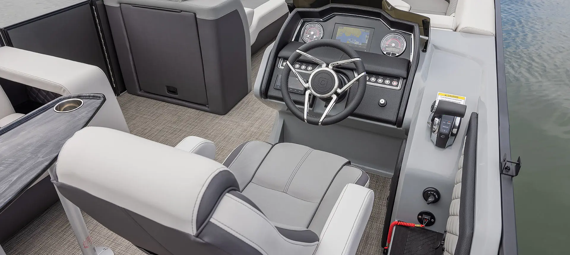 Captain's chair and helm on a Godfrey AquaPatio Entertainment pontoon boat.