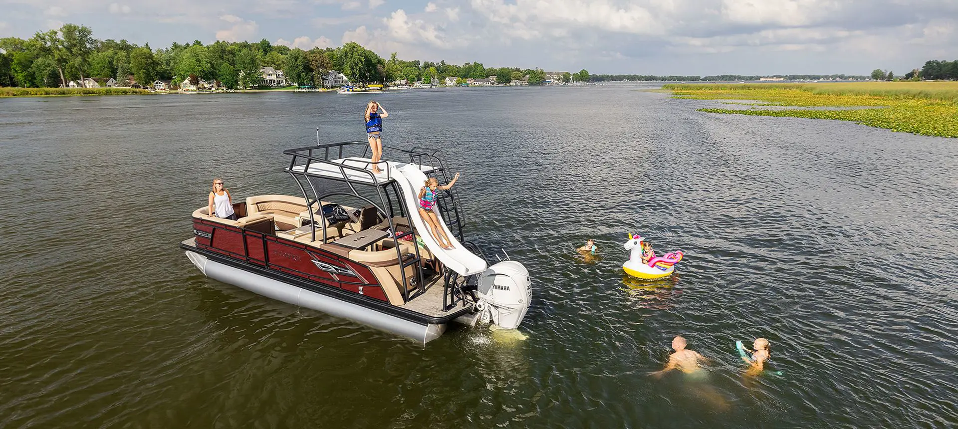 family swimming around a godfrey aquapatio sundeck pontoon