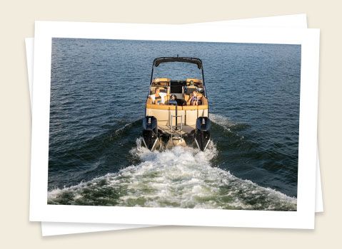 godfrey aquapatio twin pontoon speeding across a lake