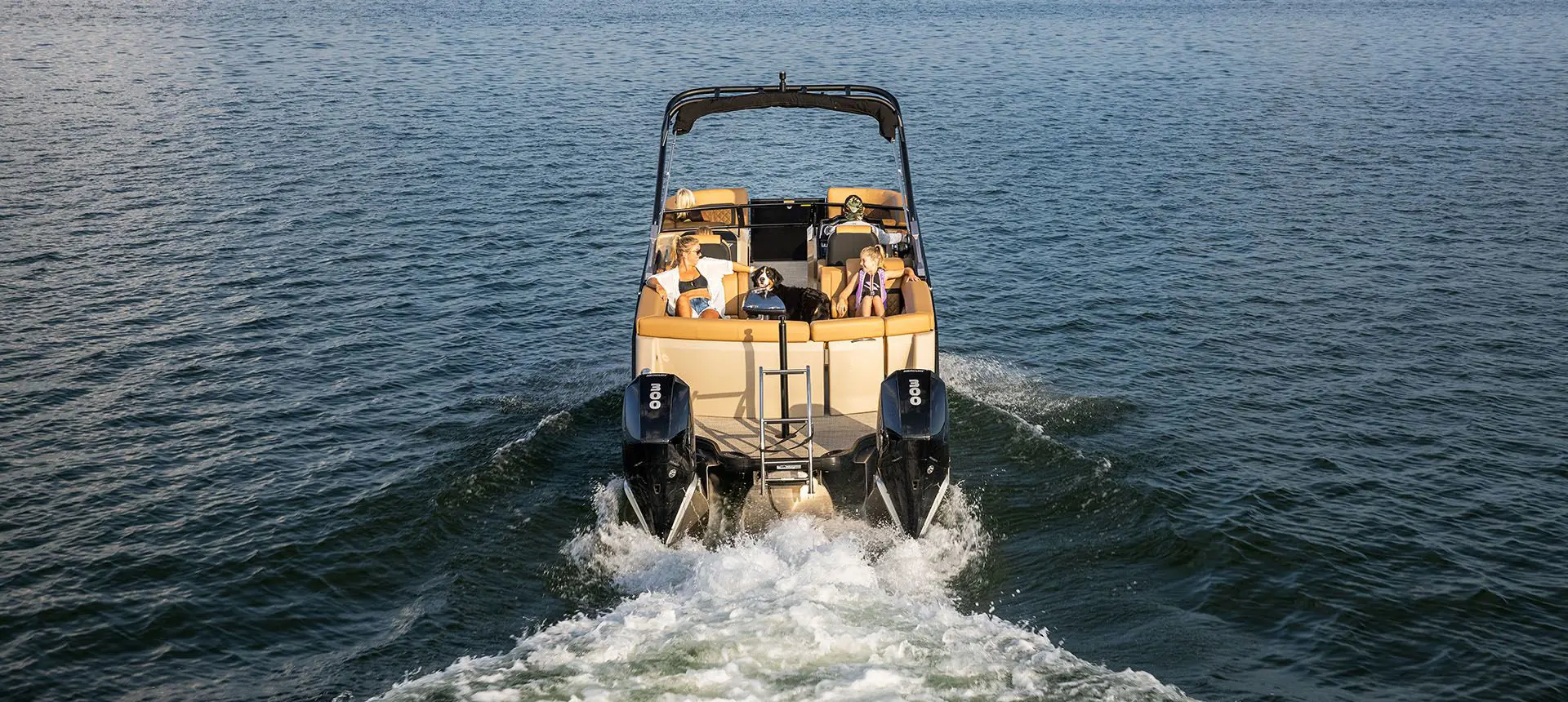 stern view of a godfrey aquapatio winshield twin tritoon cruising on a lake