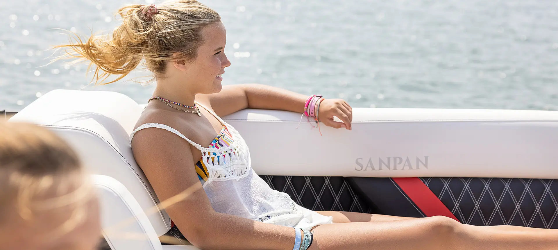 young lady relaxing on a godfrey sanpan split bench pontoon