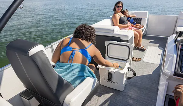 woman digging into a cooler on a godfrey sanpan split bench pontoon