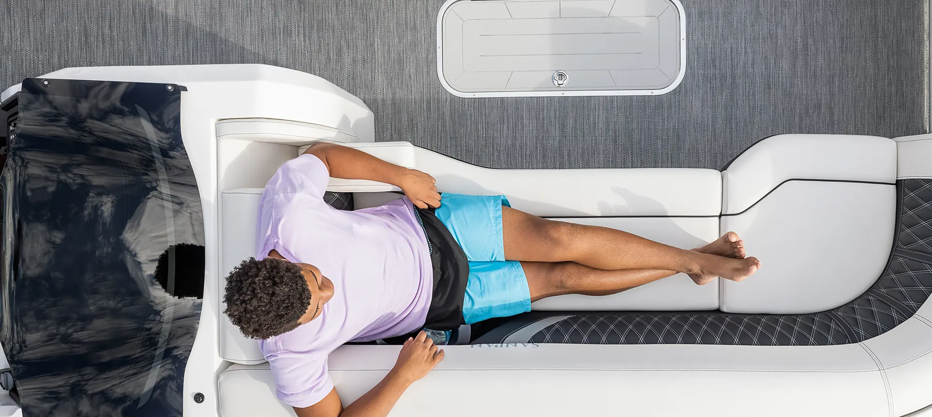 aerial view of a man sitting comfortably on the bow of a godfrey sanpan twin tritoon
