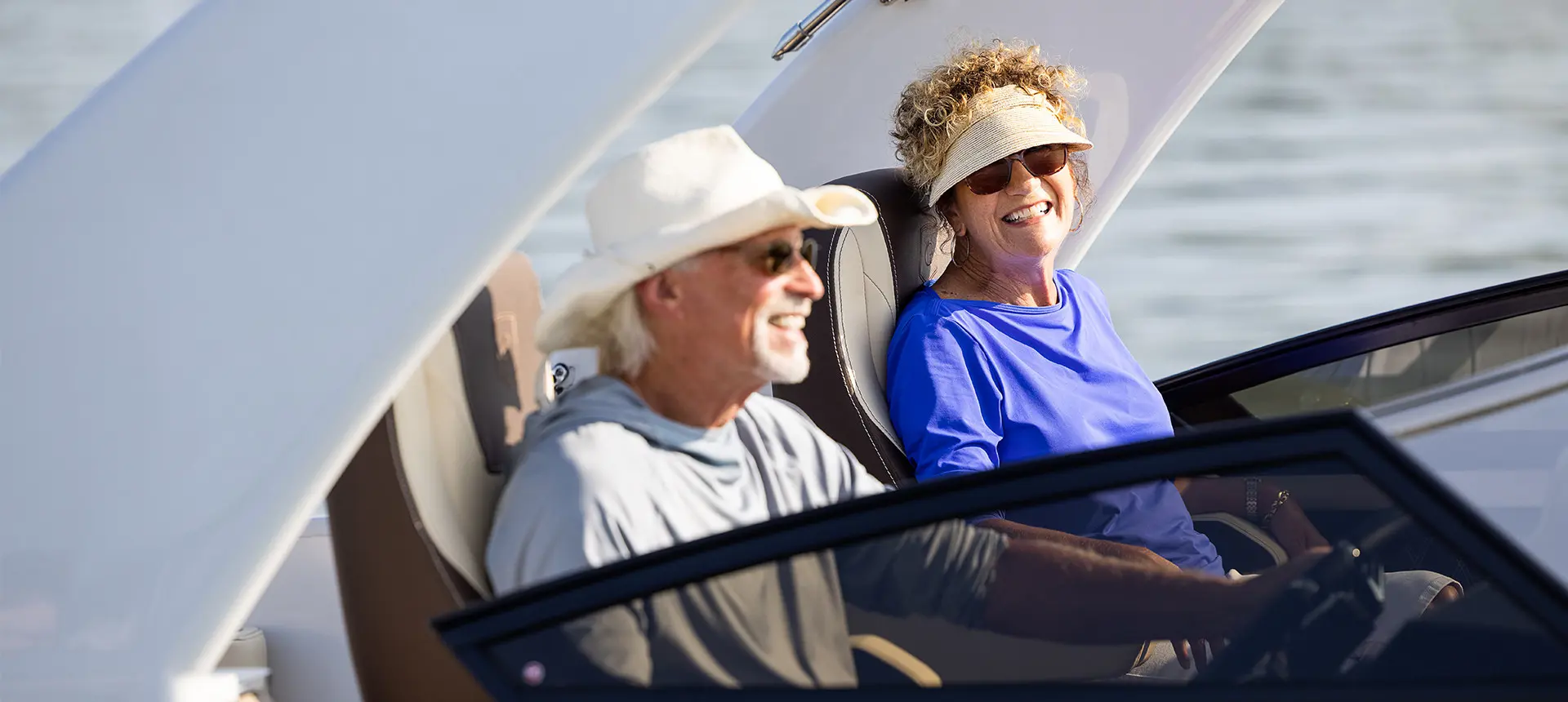 Couple assis dans les sièges copilotes d’un ponton Godfrey Sanpan Windshield.
