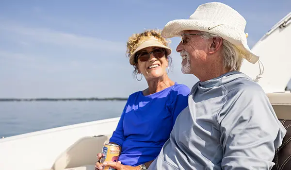 Couple souriant sur un ponton Godfrey Sanpan Windshield.