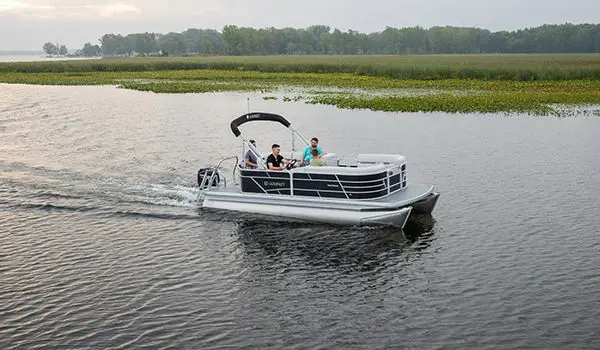 friends driving on a lake in their godfrey xperience cruise pontoon