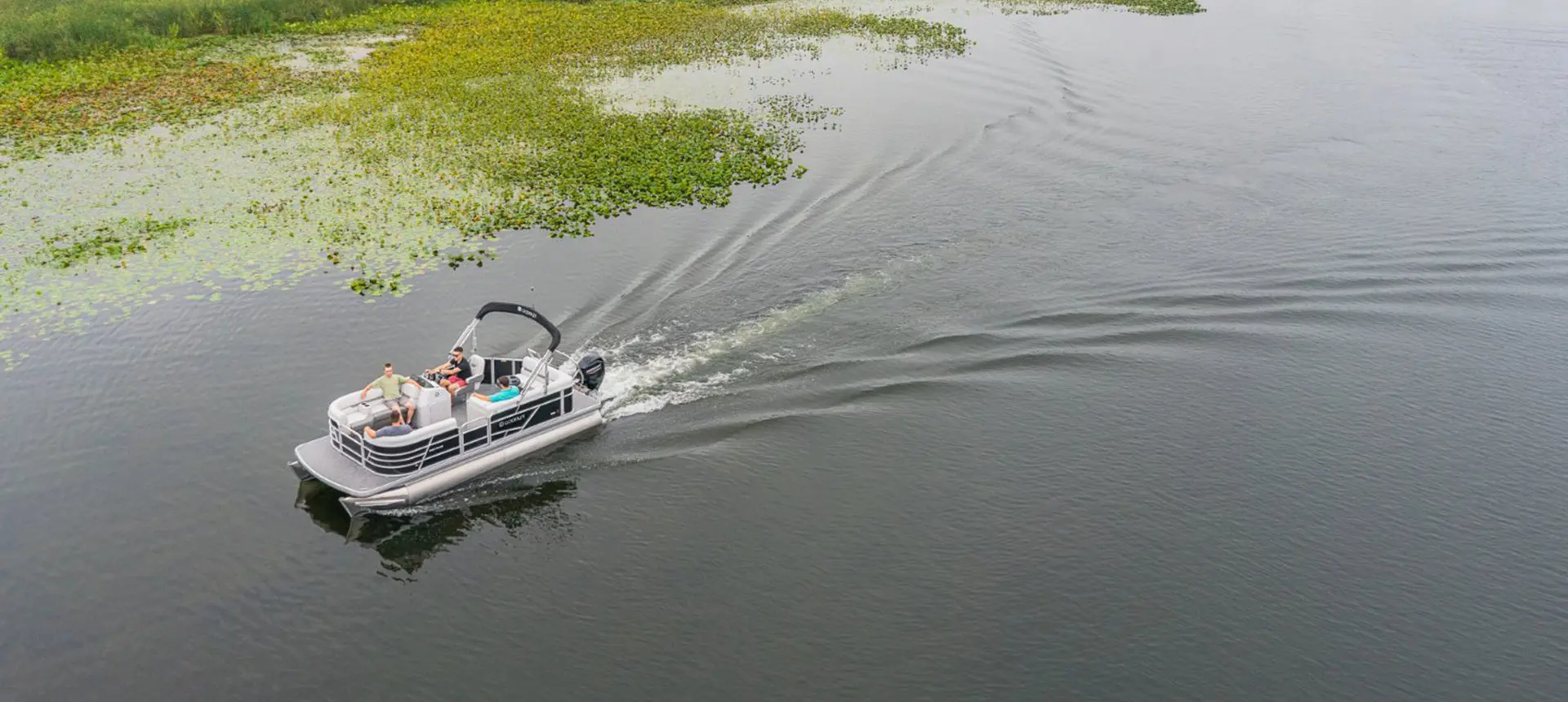 aerial view of a godfrey xperience cruise pontoon cruising on a lake