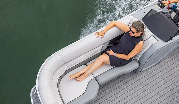 woman relaxing on the bow split bench seat on a godfrey monaco series pontoon
