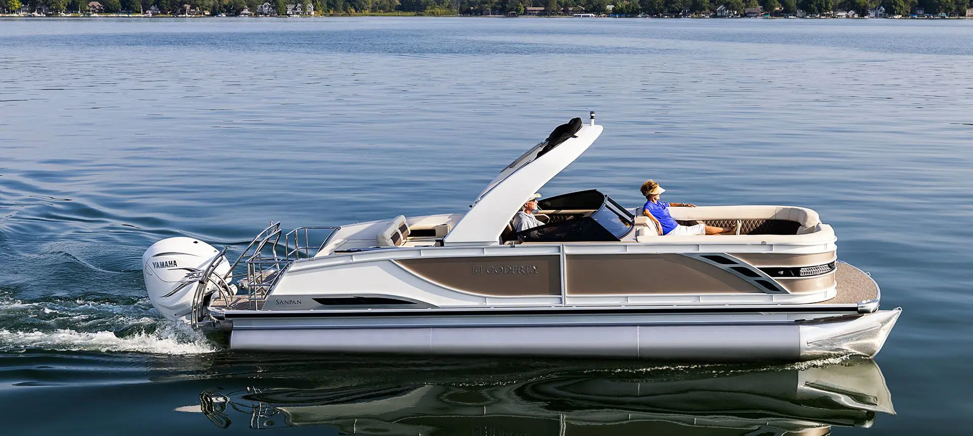 side profile of a godfrey sanpan series pontoon cruising on a lake