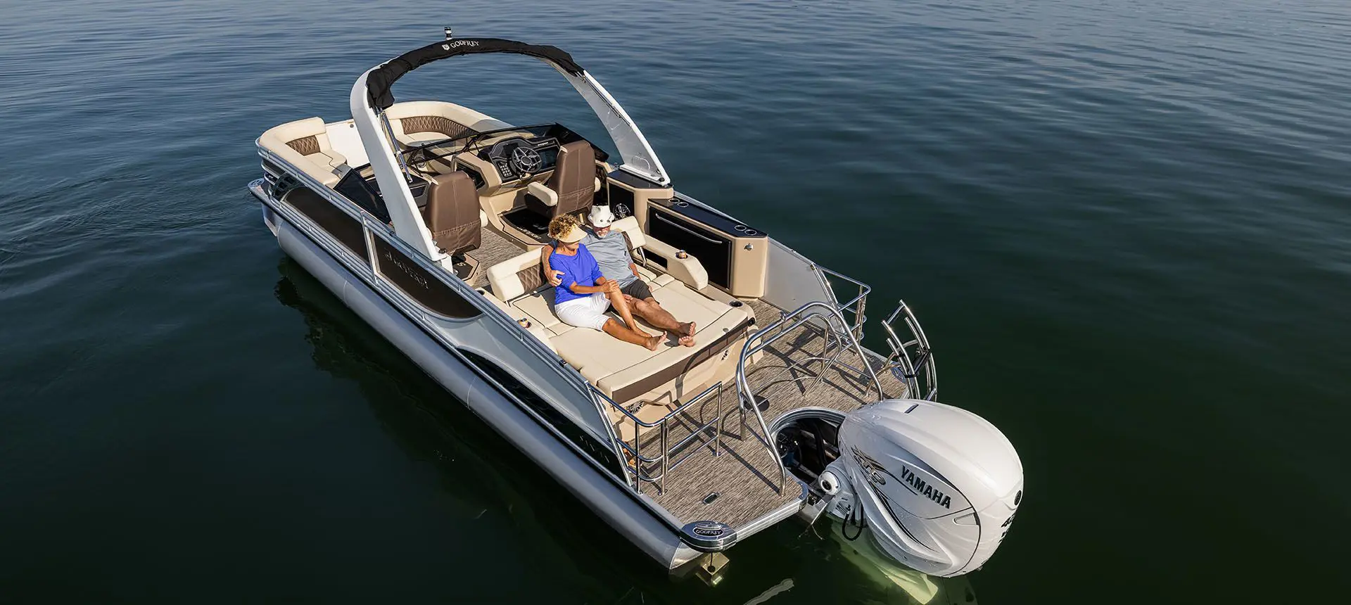couple relaxing on the swingback seat on a godfrey sanpan series pontoon