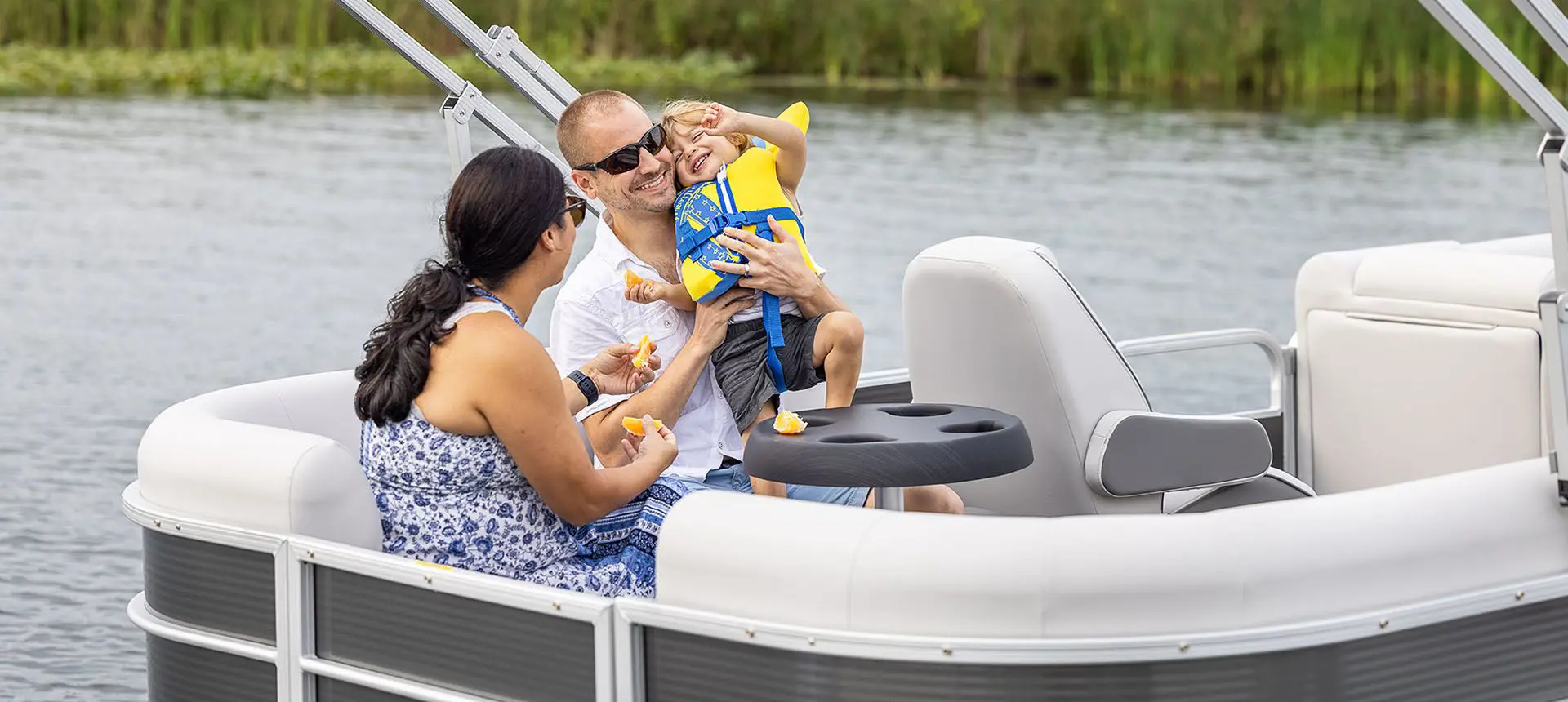 family relaxing together on a godfrey xperience split bench pontoon