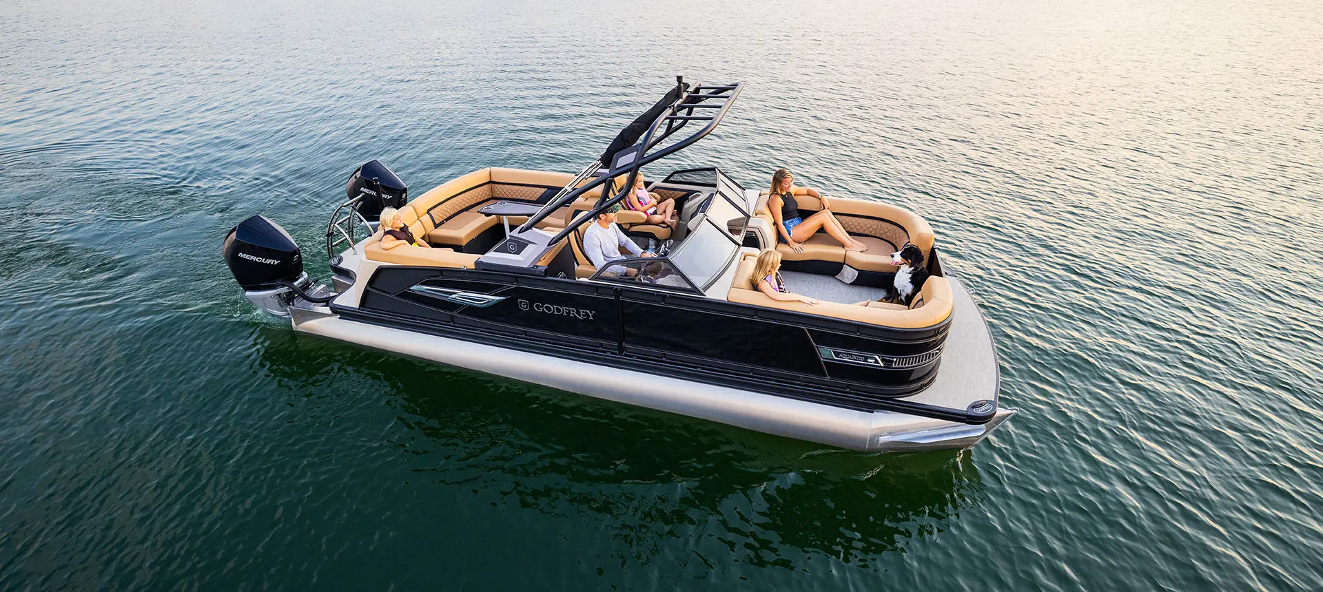 Family floating on a lake with their Godfrey AquaPatio Lounge pontoon boat.